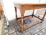 une table en bois avec un tapis bleu et blanc posé au sol