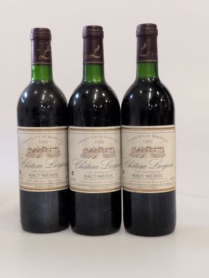 trois bouteilles de vin rouge sont alignées sur une surface blanche