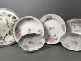 several plates and bowls sitting on a table with a gray background