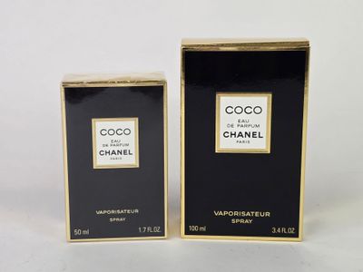 un gros plan sur deux flacons de parfum posés sur une surface blanche