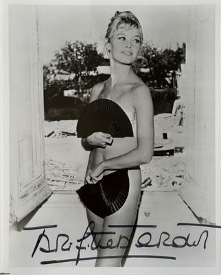 black and white photograph of a woman in a bathing suit holding a fan
