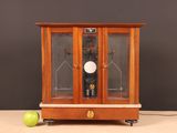 a small wooden cabinet with a clock inside of it