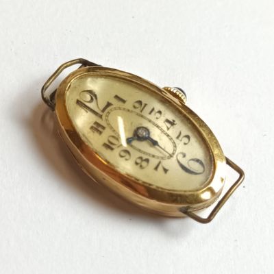 a small gold clock that is sitting on a white surface