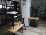 des tables et des chaises dans un restaurant où un panneau « Wi-Fi » est accroché au mur