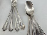 a lot of silver spoons and forks on the table