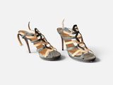 a pair of women ' s high heeled sandals with straps