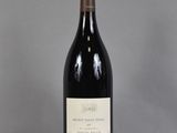 une bouteille de vin posée sur une table à côté d'un verre