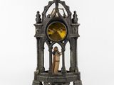 a statue of a man and a woman standing in front of a clock