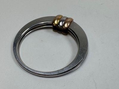 a silver ring with a gold bead on it