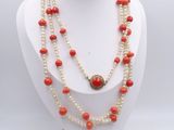 a close up of a necklace on a mannequin with red beads