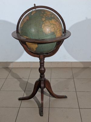 a small table with a globe on it and a shadow on the wall