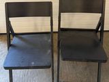 two black chairs sitting next to each other in a room