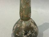 a green glass vase sitting on top of a table