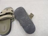 pair of men ' s slippers on a bed with a white sheet