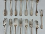 un grand nombre de cuillères et de fourchettes en argent disposées sur une table