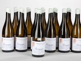 six bouteilles de vin sont alignées sur une table