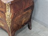 a marble topped chest of drawers in the corner of a room