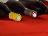 several bottles of wine are lined up on a red cloth