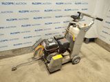 un gros plan d'une machine posée sur un sol en béton, devant un mur