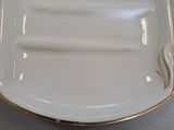 a white plate with gold trim on it on a table