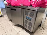 two freezers with bags on top of them on the floor