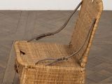 a wicker chair that is sitting on a wooden floor
