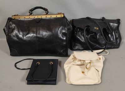 deux sacs à main noirs et blancs et un sac à main noir posés sur une table