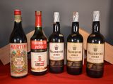 several bottles of wine are lined up on a red table