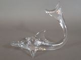 a glass sculpture of a dolphin that is sitting on a table