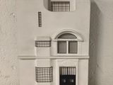 a small white building with a black door and windows
