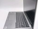 a silver laptop with a black keyboard on a white surface