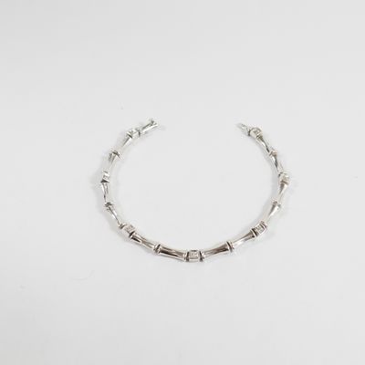 gros plan d'un bracelet en argent sur une surface blanche