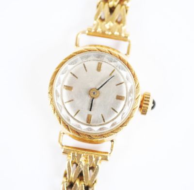 une image d'un gros plan d'une montre-bracelet sur une surface blanche