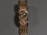 a close up of a gold watch on a gray surface