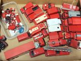 une boîte remplie de camions de pompiers et de camions jouets