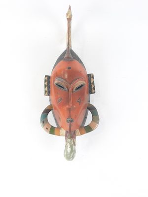 an image of a wooden mask hanging on a wall