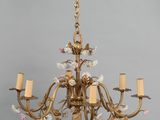 une image représentant un lustre orné de fleurs et de bougies suspendu au plafond