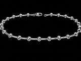 a close up of a silver bracelet on a black background