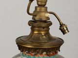 a large vase with a brass handle on a table