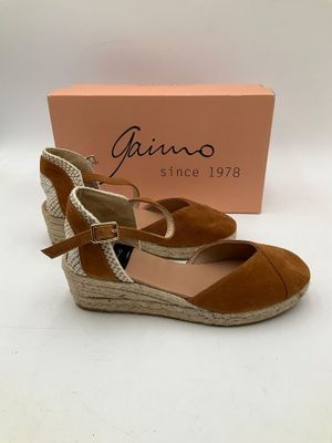 un gros plan sur une paire de chaussures avec une boîte en arrière-plan