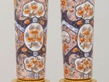 pair of vases with floral designs on them sitting on a table
