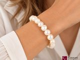 woman wearing a white shirt and a pearl bracelet on her wrist