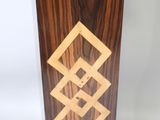 a close up of a wooden vase with a geometric design on it