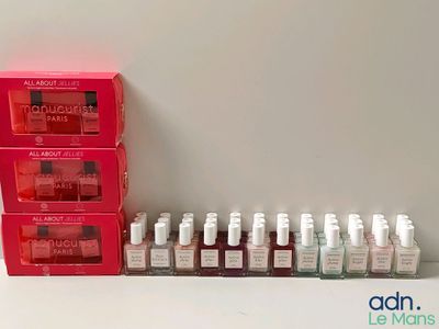 bottles of nail polish are lined up on a shelf next to a red box