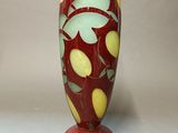 a red vase with a green and yellow design on it