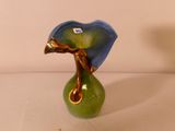 un vase vert contenant une fleur bleue
