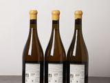 three bottles of wine sitting on top of a wooden table