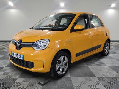La petite voiture jaune est garée dans le garage, sur un sol à damier.