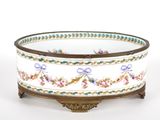 a white bowl with flowers on it on a stand