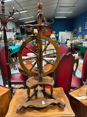 un rouet posé sur une table en bois dans une pièce